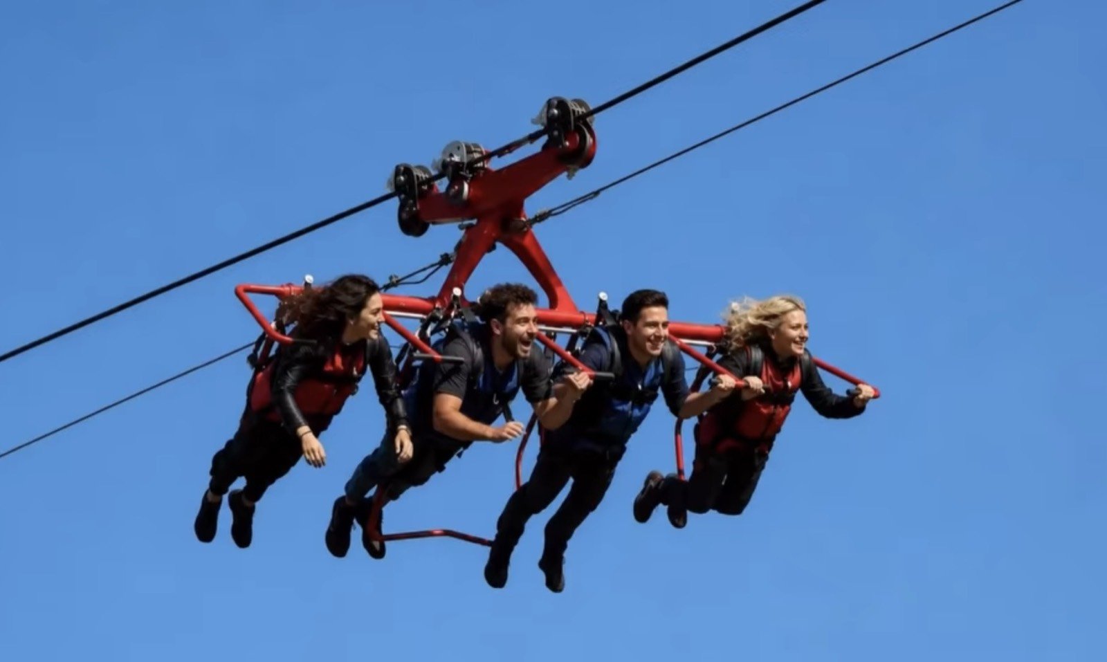 Quattro persone in volo appese al cavo d'acciaio dello sky glider